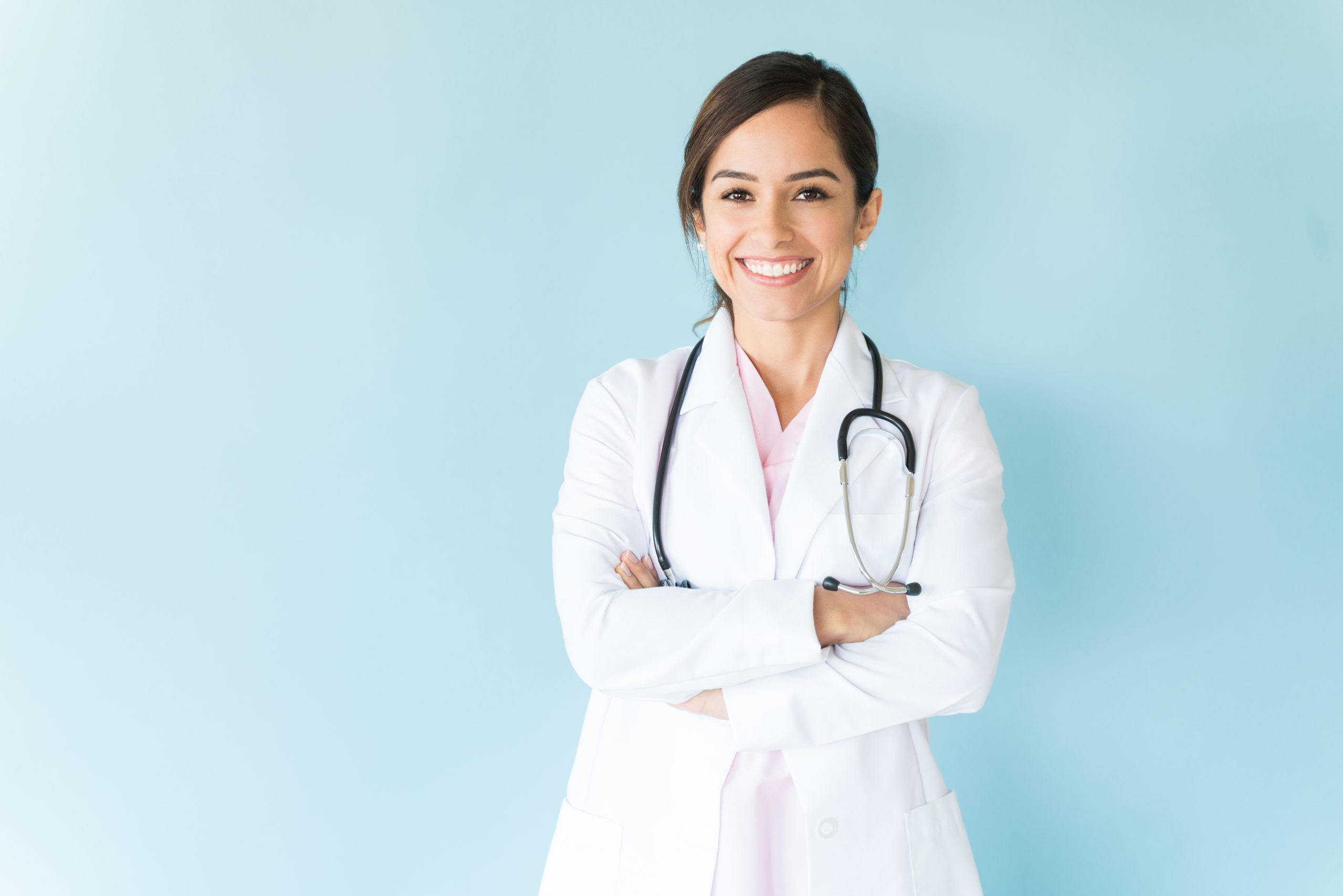 Smiling,Female,Doctor,In,Lab,Coat,With,Arms,Crossed,Against