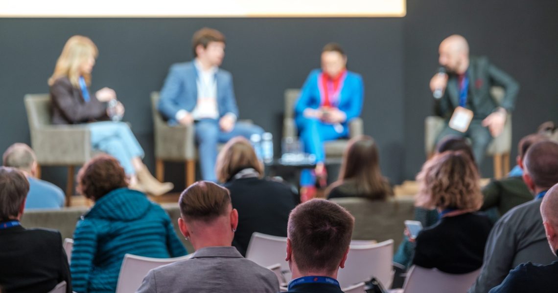 Audience,Listens,To,Panel,Discussion,At,Conference,Hall,,Rear,View