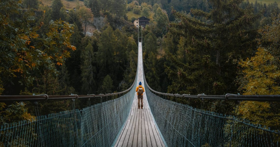 Young,Traveler,Man,Dressed,In,Yellow,Jacket,Crosses,Hiking,On