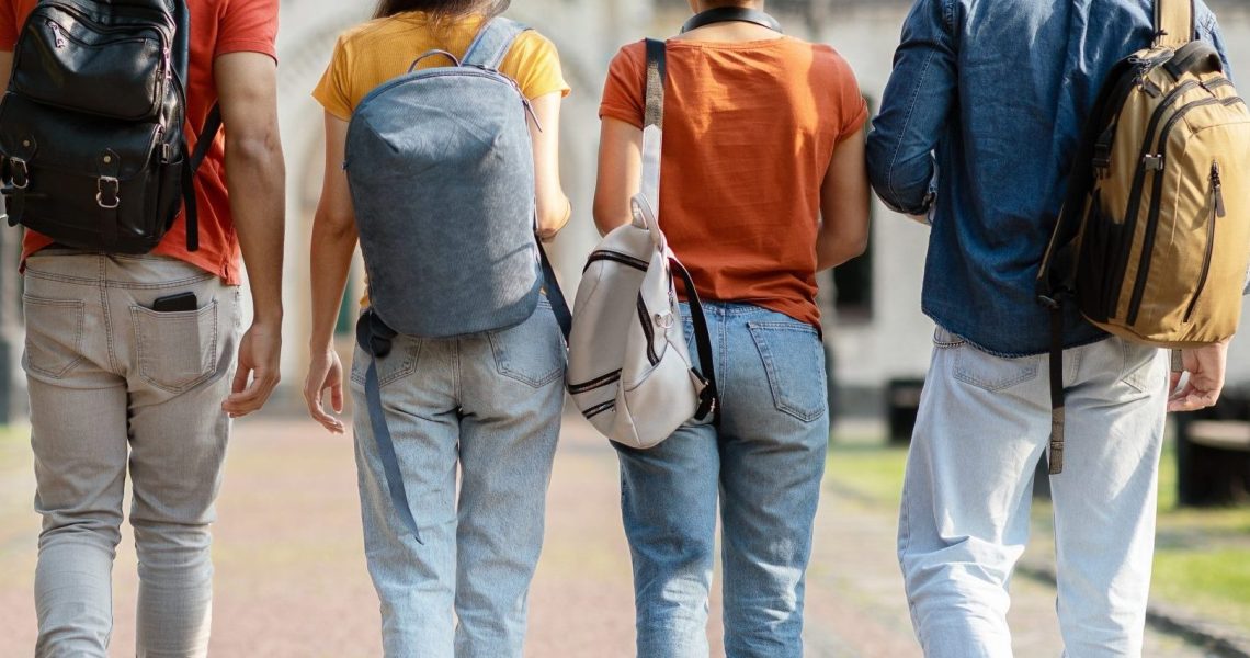 Group,Of,Five,Students,With,Backpacks,Walking,At,University,Campus