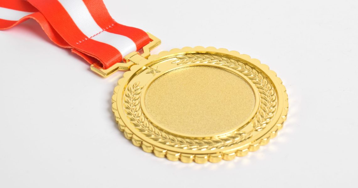 Gold,Medal,With,Red,And,White,Ribbon,Isolated,On,White